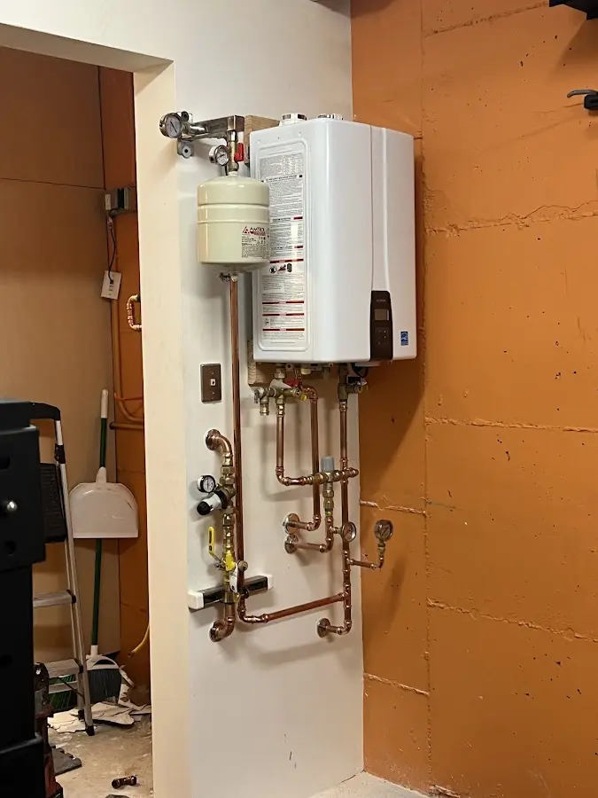 Plumbing technician inspecting water heater connections in McSherrystown